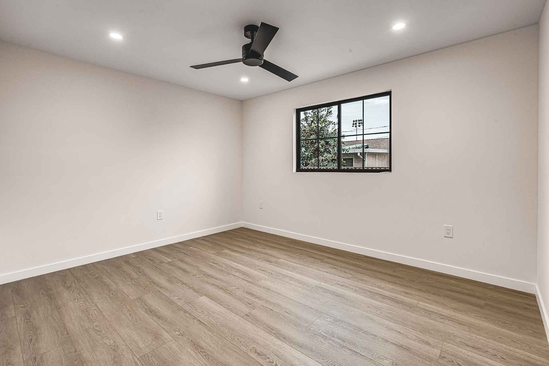 Empty Bedroom with Wood Flooring and Black Ceiling Fan