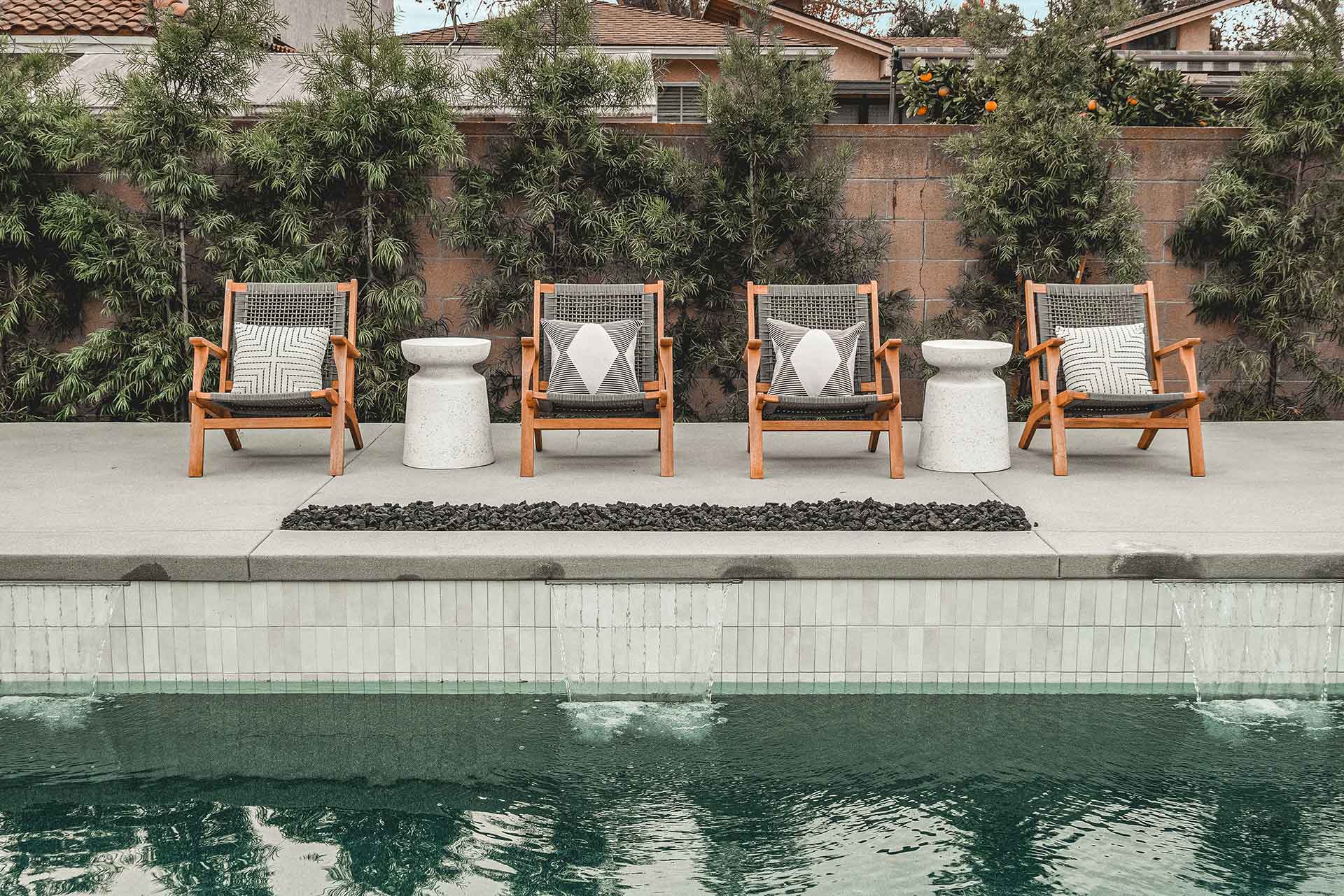 Backyard Pool with Waterfall Features and Wood Lounge Chairs