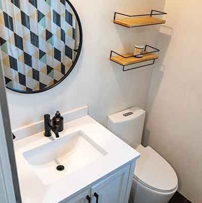 Small ADU Bathroom with White Vanity, Toilet, and Floating Shelves Small ADU Bathroom with White Vanity, Toilet, and Floating Shelves