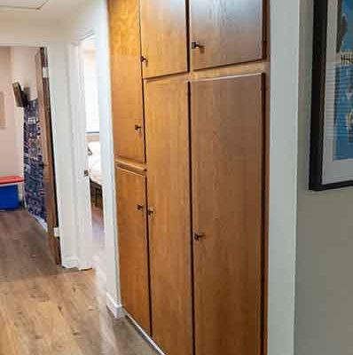 Hallway with Floor-to-Ceiling Wood Grain Storage Cabinets Hallway with Floor-to-Ceiling Wood Grain Storage Cabinets